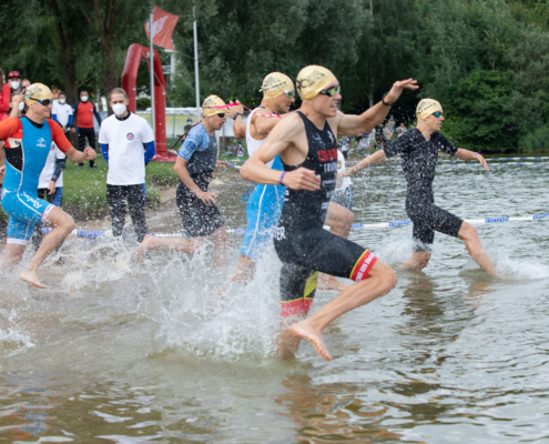 Sportler sprinten ins Wasser