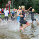 Sportler sprinten ins Wasser