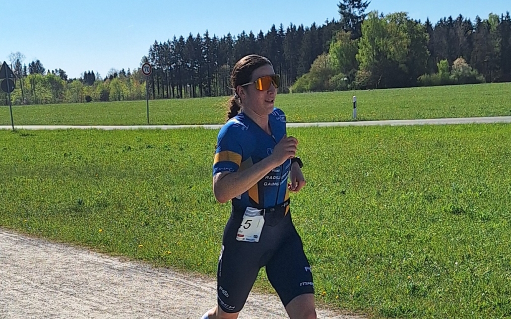 Frau läuft vor grüner Wiese