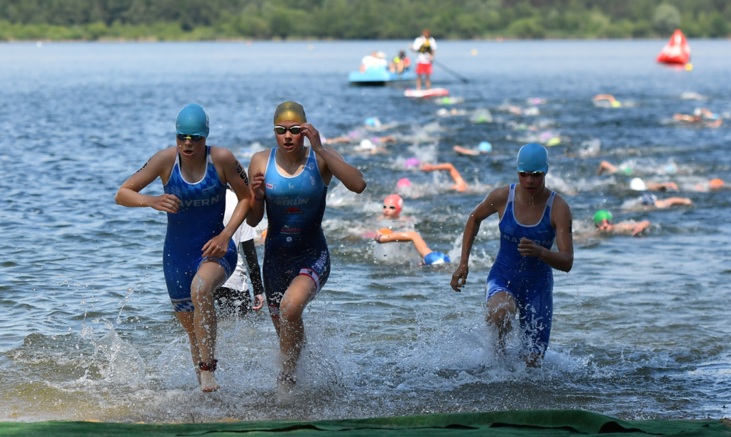 drei Sportlerinnen kommen aus dem See
