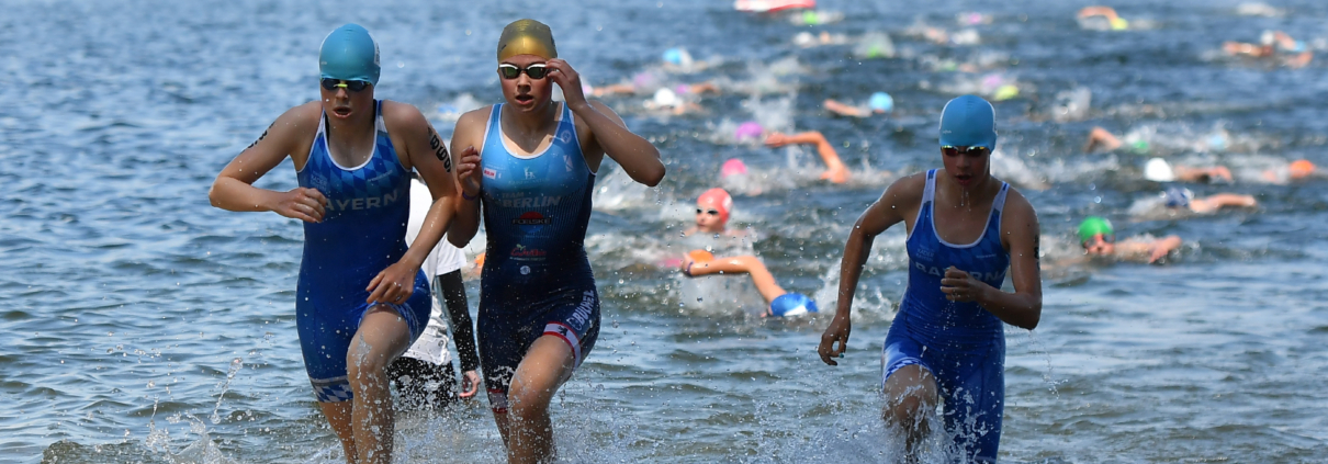 drei Sportlerinnen kommen aus dem See