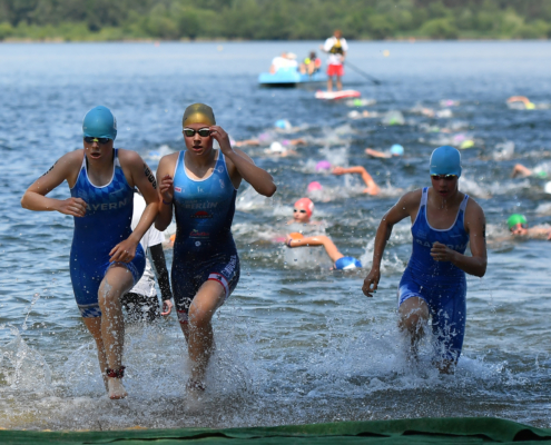 drei Sportlerinnen kommen aus dem See