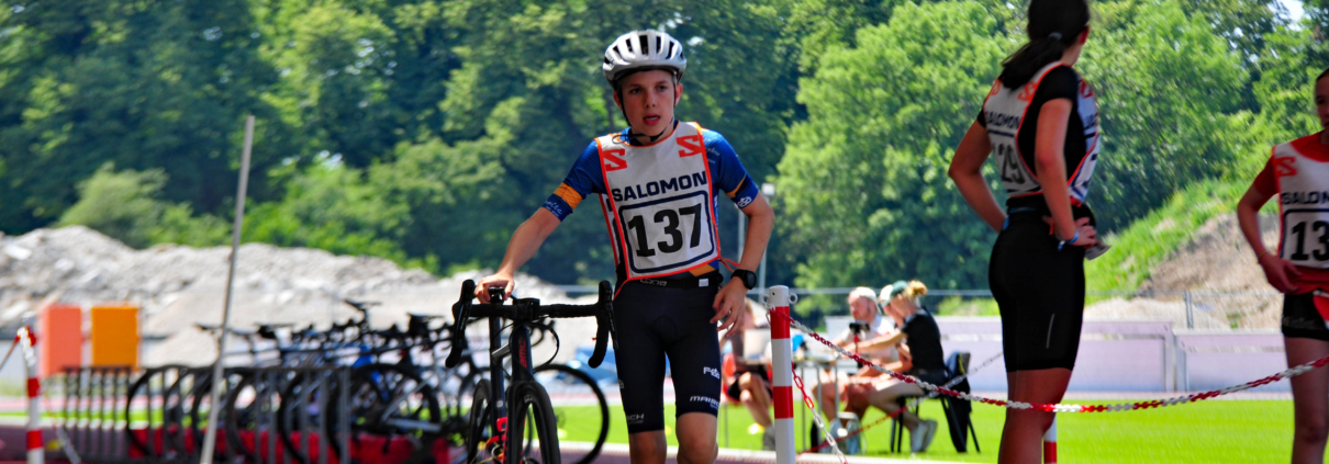 Junger Sportler schiebt sein Rad