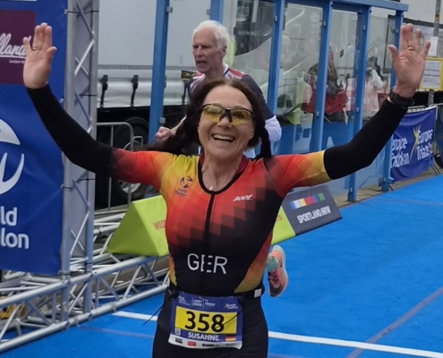 Frau läuft mit erhobenen Händen über Ziellinie