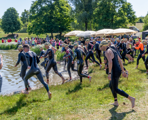 Schwimmer laufen ins Wasser Start beim Triathlon Obernzenn