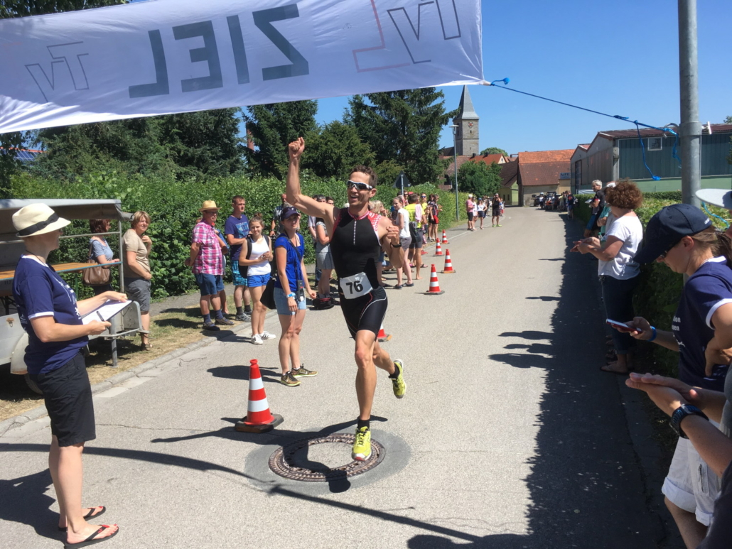 Sportler läuft durch das Ziel