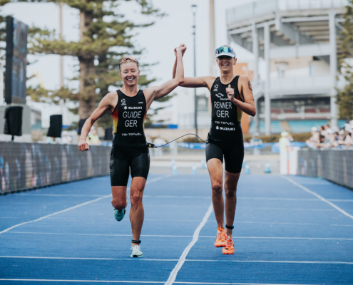 Zwei Sportlerinnen laufen gemeinsam ins Ziel