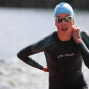 Schwimmerin im Neoprenanzug kommt aus dem Wasser