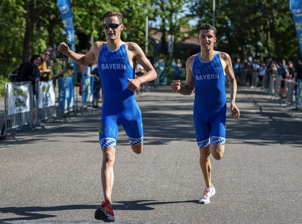 zwei Sportler in blauen Anzügen laufen