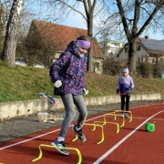 Kinder laufen über Hürden