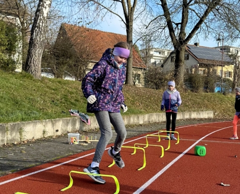 Kinder laufen über Hürden