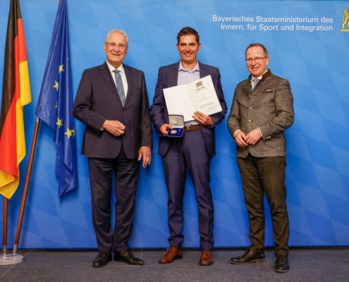 Drei Männer vor blauer Wand