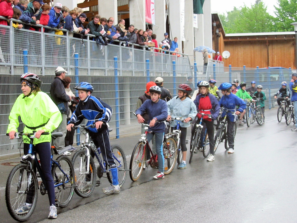 Kinder auf Fahrrädern mit Zuschauern