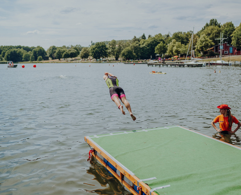 Sprung vom Steg ins Wasser beim tadtwerke Schüler und Jugendtriathlon Hof