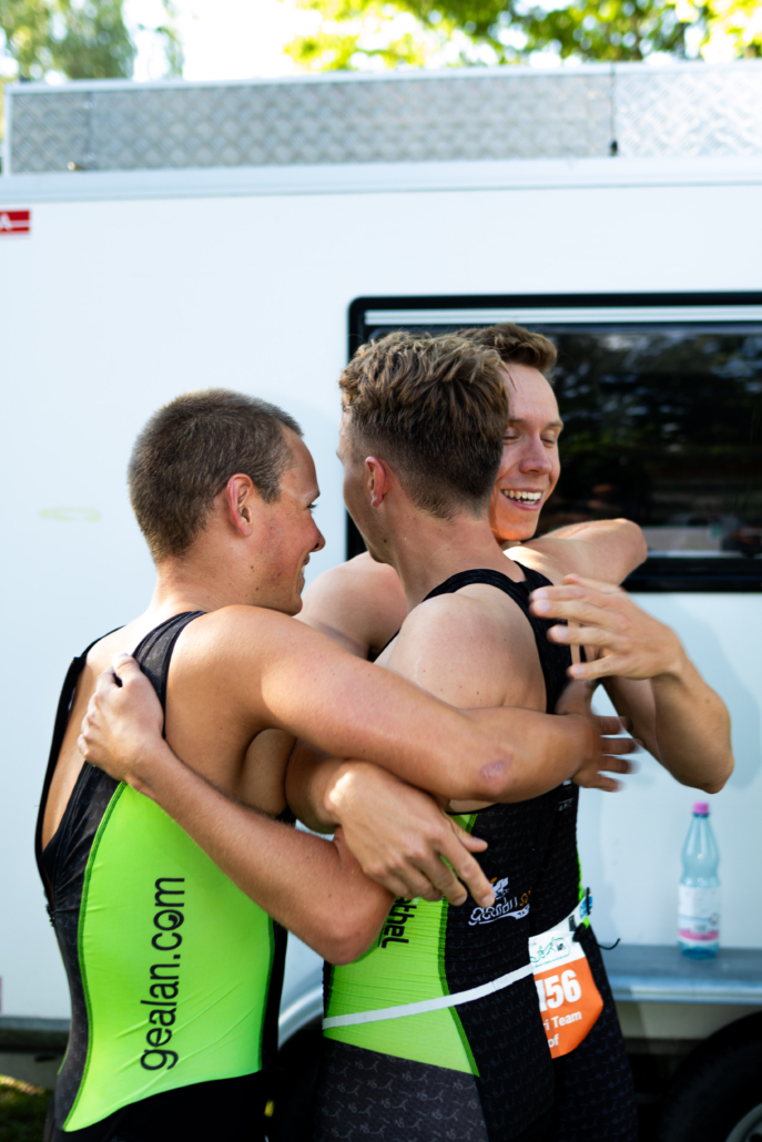 Drei Sportler umarmen sich