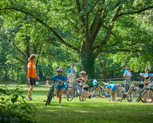 Kinder schieben Fahrrad in Wettkampf
