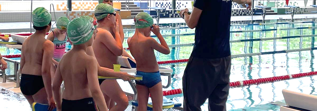Kinder und Trainer in Schwimmbad