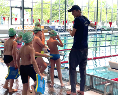 Kinder und Trainer in Schwimmbad