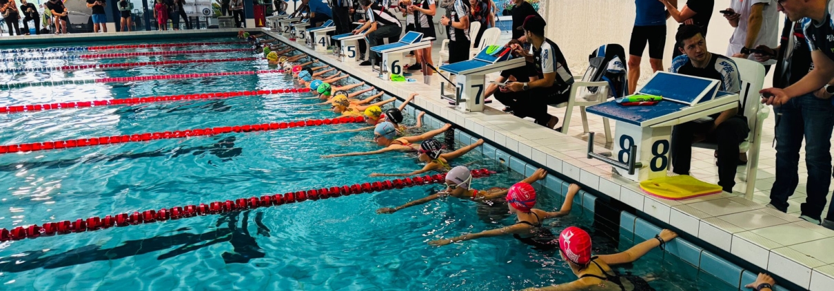 Blick in ein Hallenbad mit Kindern und Eltern am Rand