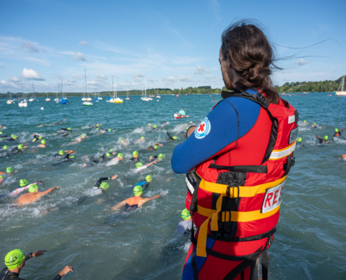 Mitarbeiter der Wasserwacht beobachtet Schwimmer im See