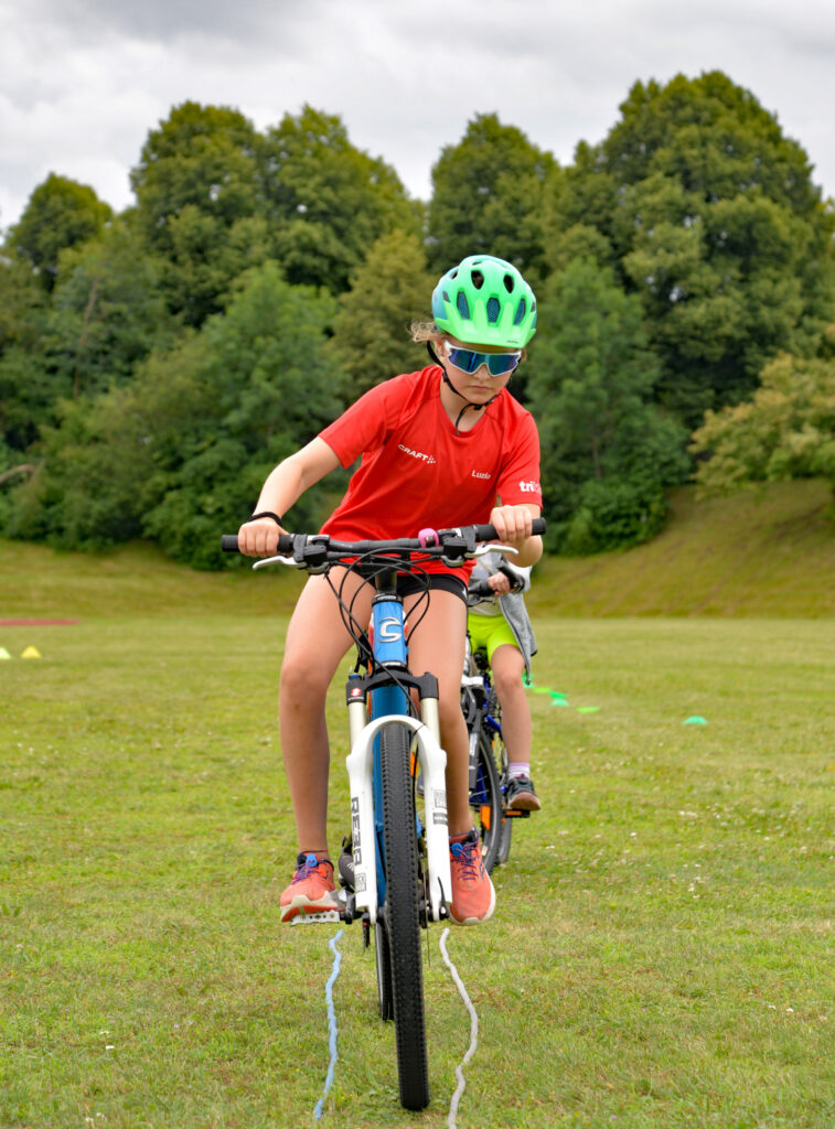 junge Sportlerin fährt mit dem Mountainbike über Parcours