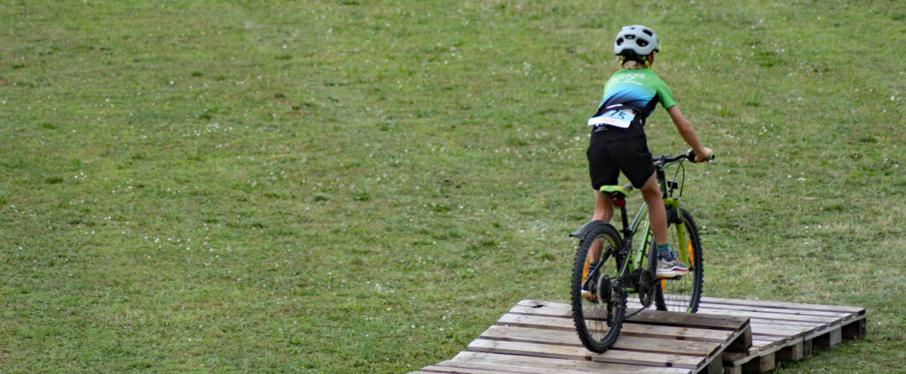junger Sportler fährt mit dem Mountainbike über Parcours