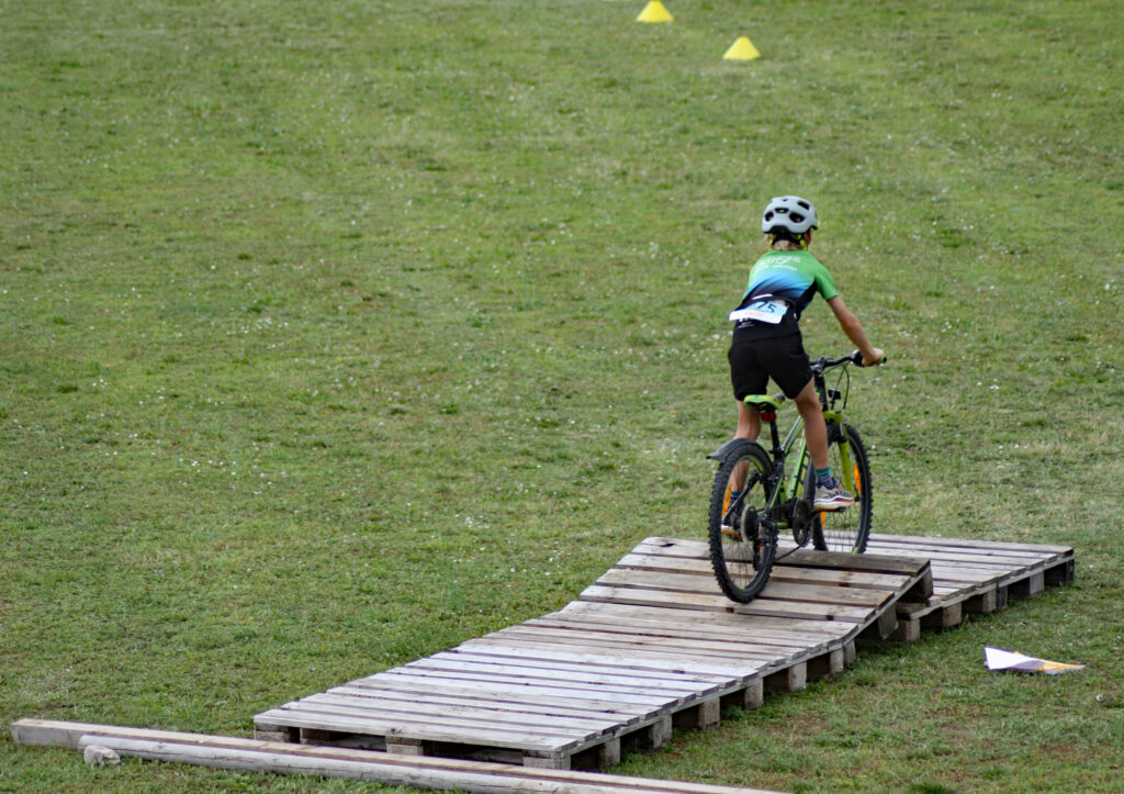 junger Sportler fährt mit dem Mountainbike über Parcours